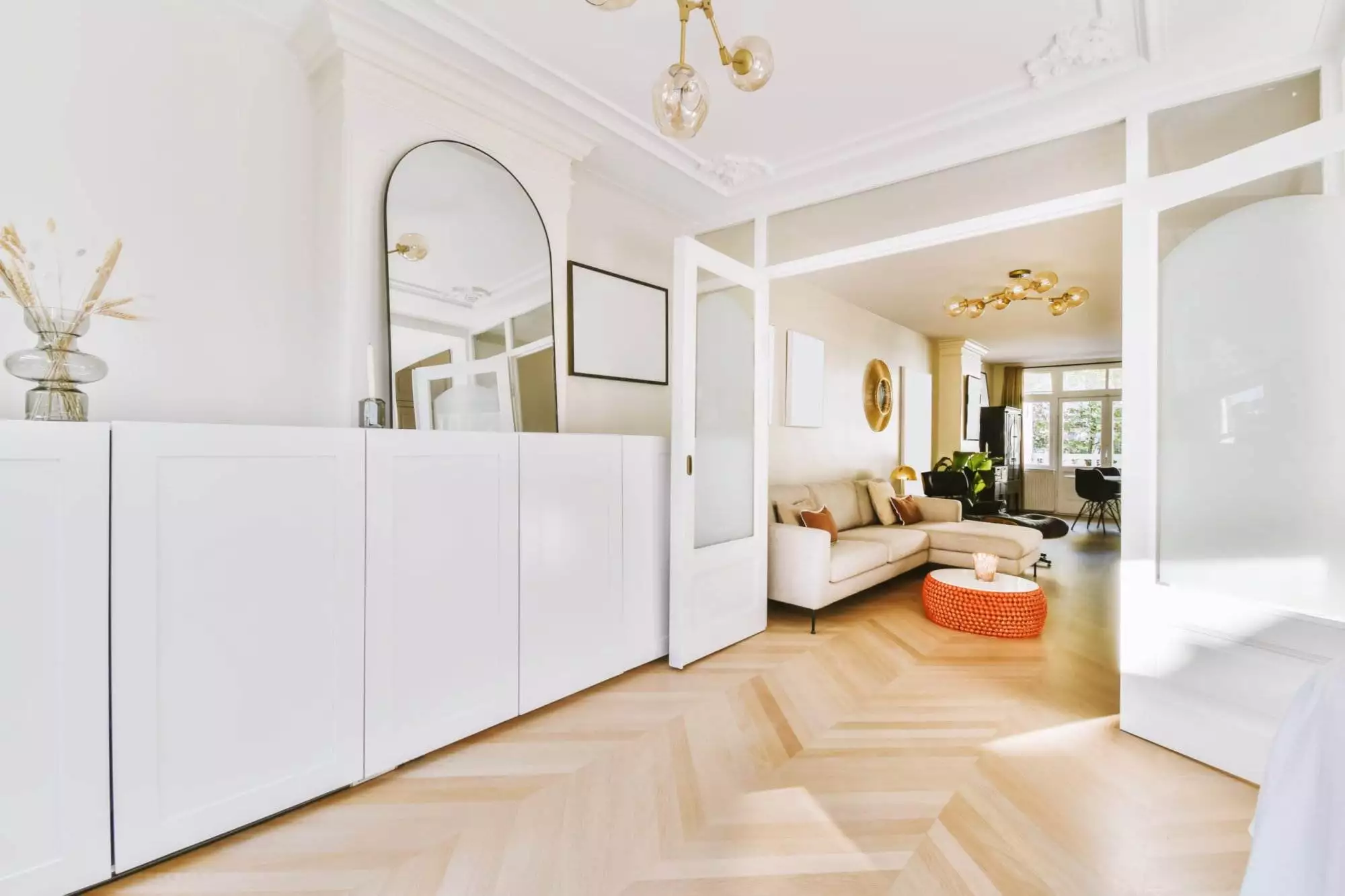 Helle, moderne Wohnzimmer-Einrichtung mit Sofa und Spiegel